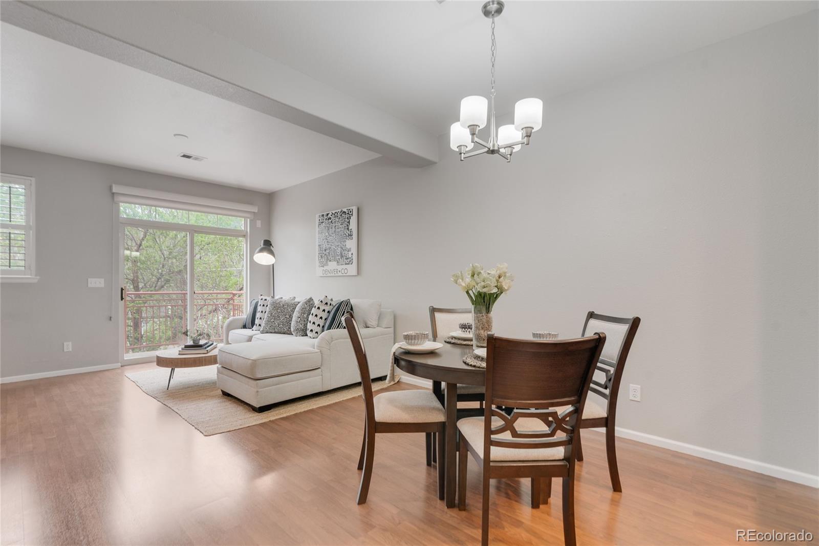 5392 Allison Street Arvada, CO 80002 - Photo 10 of 47 a dining room with wooden floor a chandelier a glass table and chairs