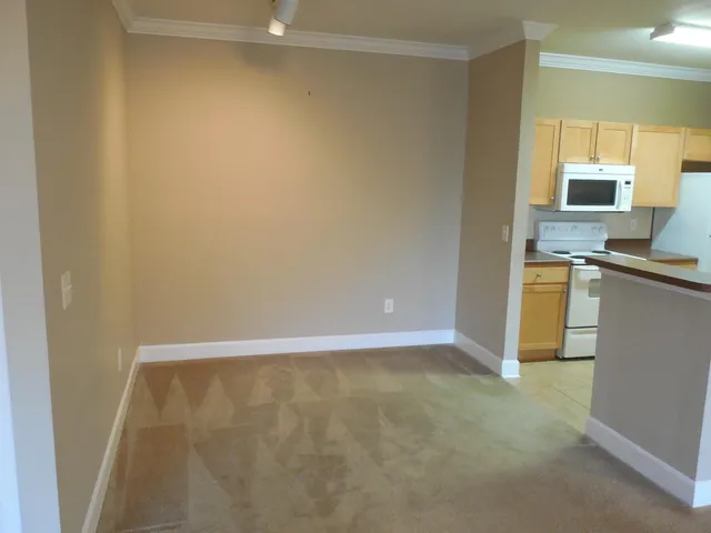 a view of kitchen with a sink a microwave and cabinets