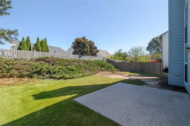 a view of a yard with yellow house