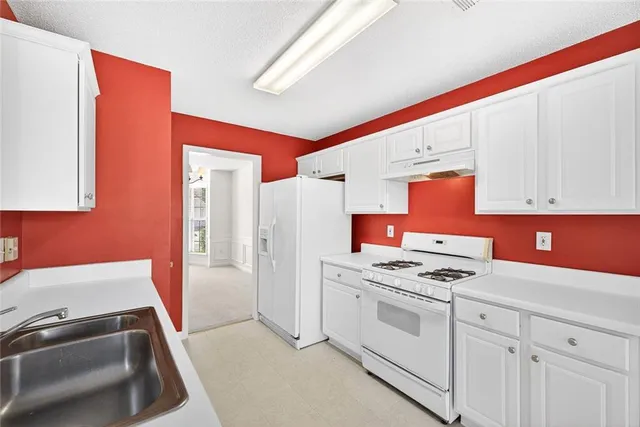 a kitchen with stainless steel appliances a stove a sink and a refrigerator