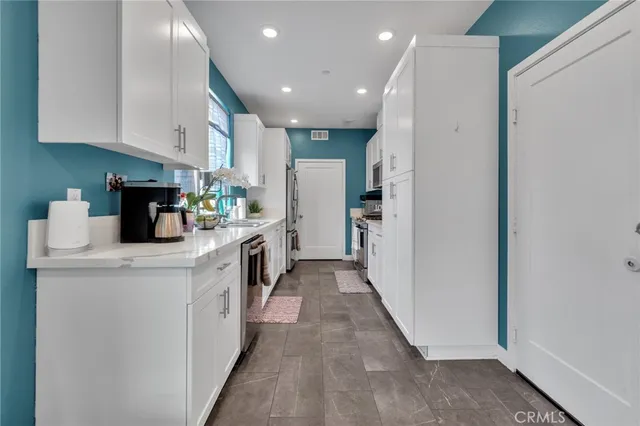 a kitchen with a sink a refrigerator and cabinets