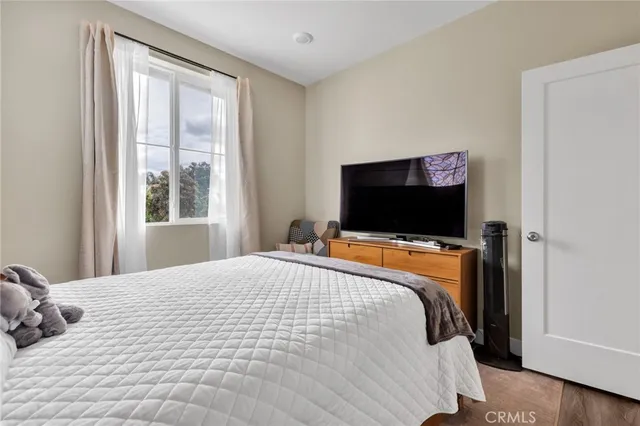 a bedroom with a bed and a flat screen tv