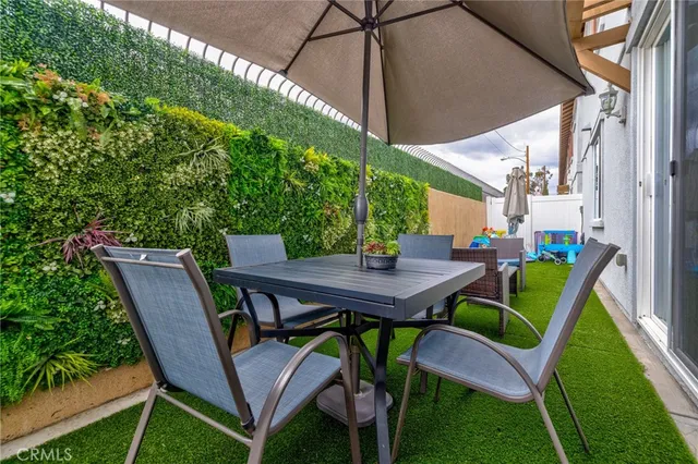 a patio with a table and chairs under an umbrella