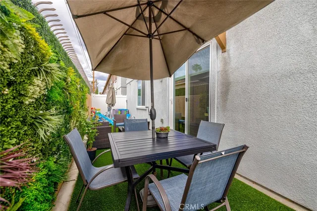 a view of deck with table and chairs under an umbrella