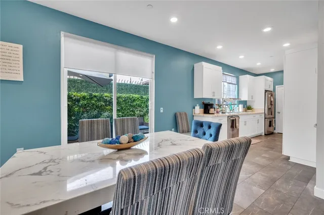 a kitchen with kitchen island granite countertop a refrigerator a stove top oven a sink and a large window