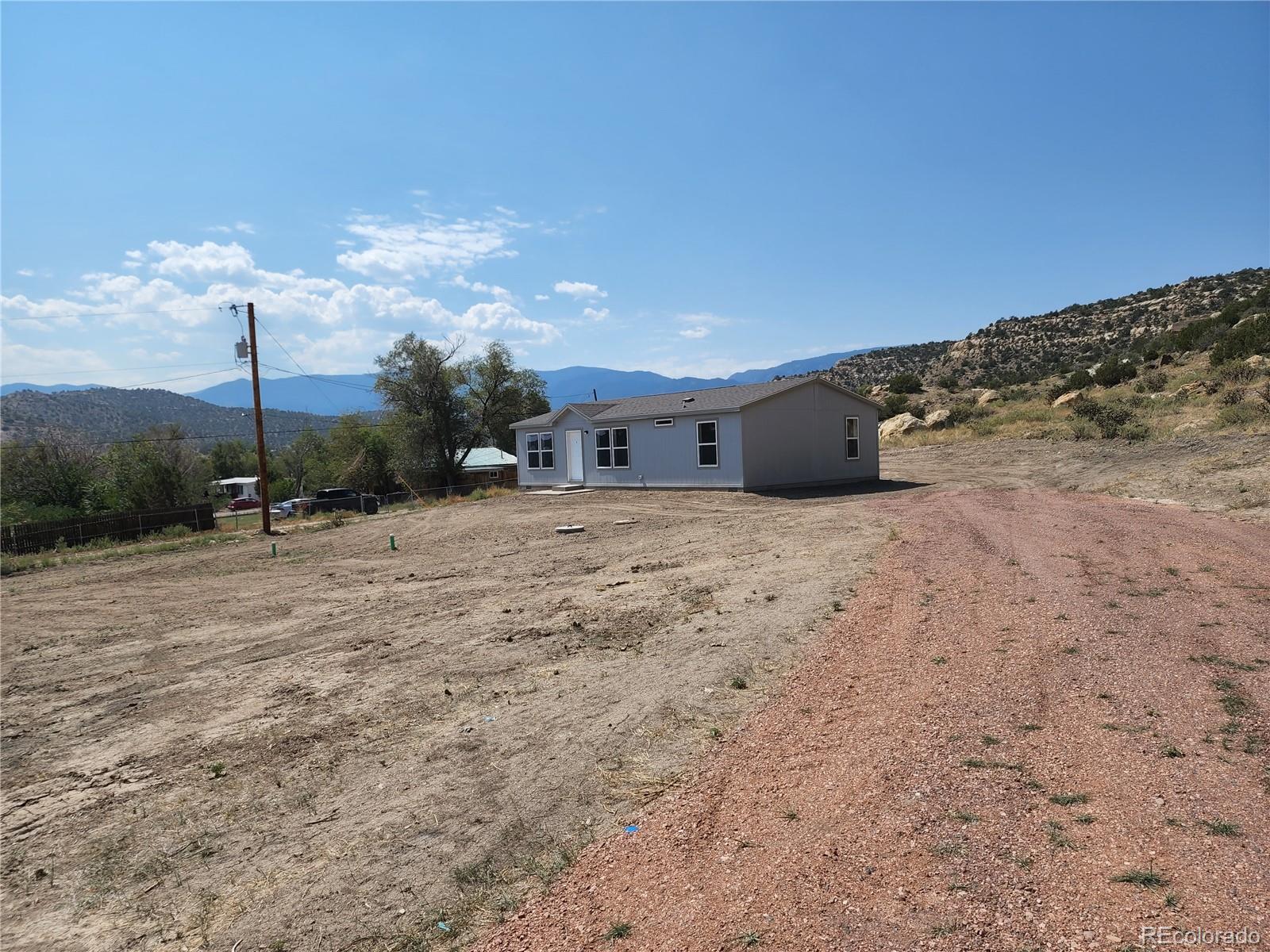 a view of a dry yard with wooden fence