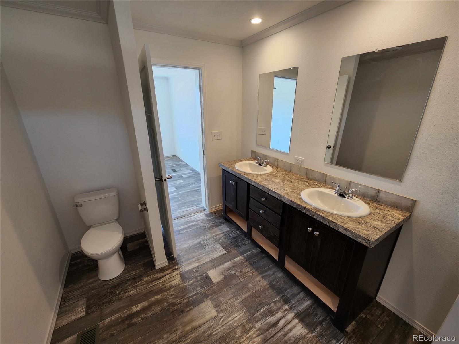 207 Willow Street Rockvale, CO 81244 - Photo 13 of 19 a bathroom with a double vanity sink mirror and toilet