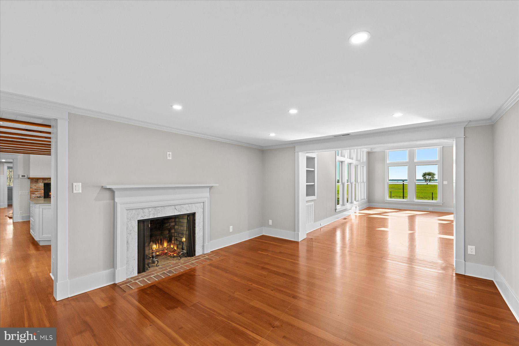 29031 Howell Point Road Trappe, MD 21673 - Photo 46 of 129 a view of an empty room with wooden floor and a fireplace