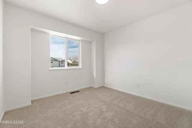 a view of empty room with wooden floor and window