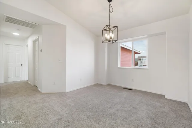 a view of a kitchen with furniture and a refrigerator