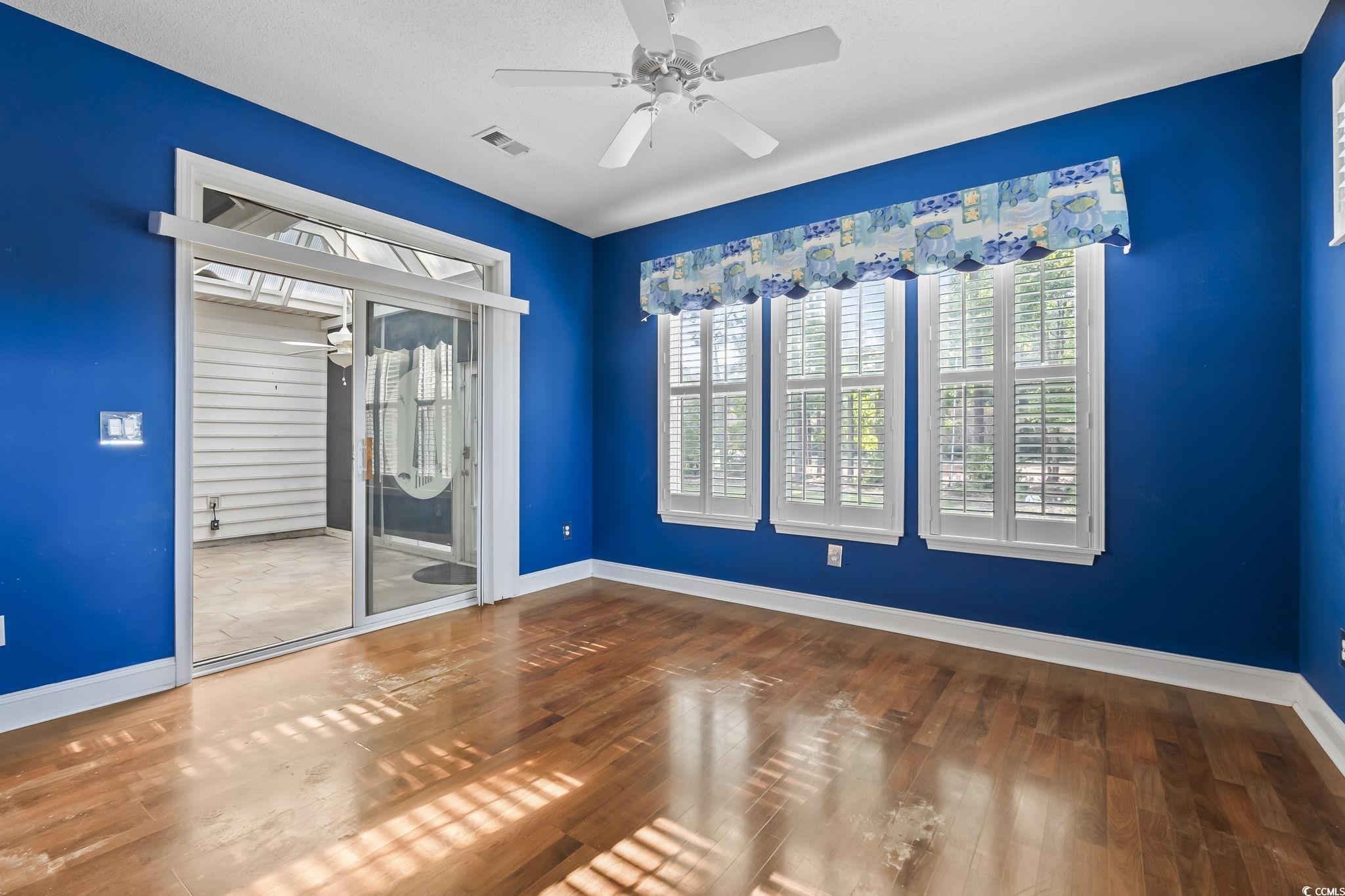743 Helms Way Conway, SC 29526 - Photo 20 of 37 Empty room featuring ceiling fan, plenty of natural light, and wood finished floors