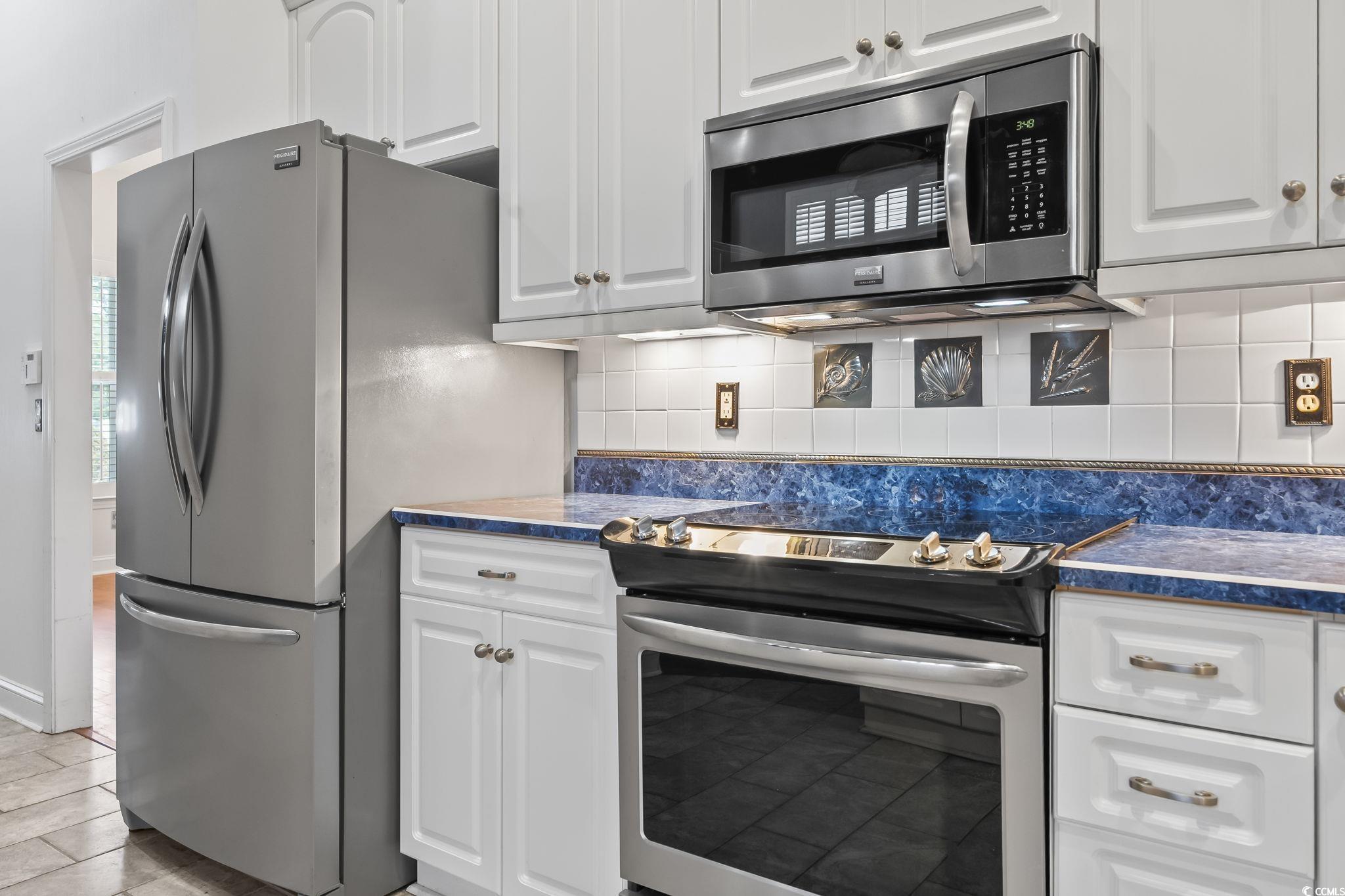 743 Helms Way Conway, SC 29526 - Photo 22 of 37 Kitchen with tasteful backsplash, stainless steel appliances, white cabinetry, and dark stone countertops