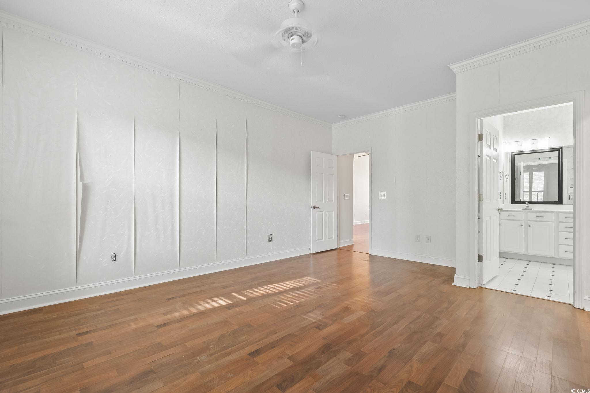 743 Helms Way Conway, SC 29526 - Photo 28 of 37 Unfurnished bedroom featuring dark wood finished floors, ornamental molding, ensuite bathroom, and a ceiling fan