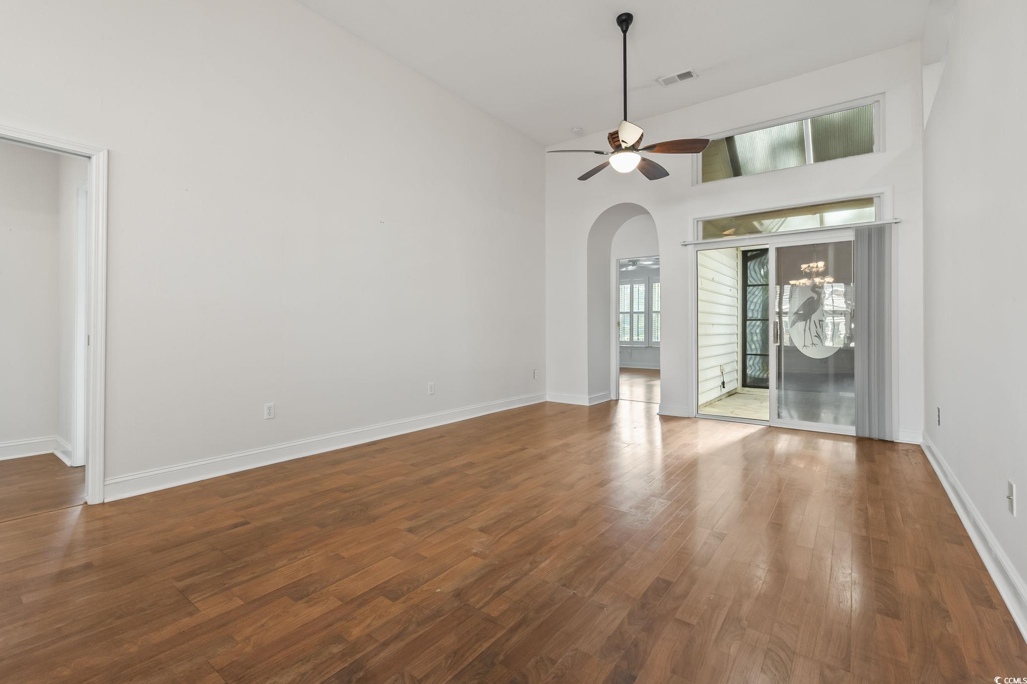 743 Helms Way Conway, SC 29526 - Photo 36 of 37 Unfurnished living room with high vaulted ceiling, dark wood-type flooring, a ceiling fan, and arched walkways
