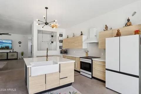 a kitchen with a sink a stove a refrigerator and white cabinets