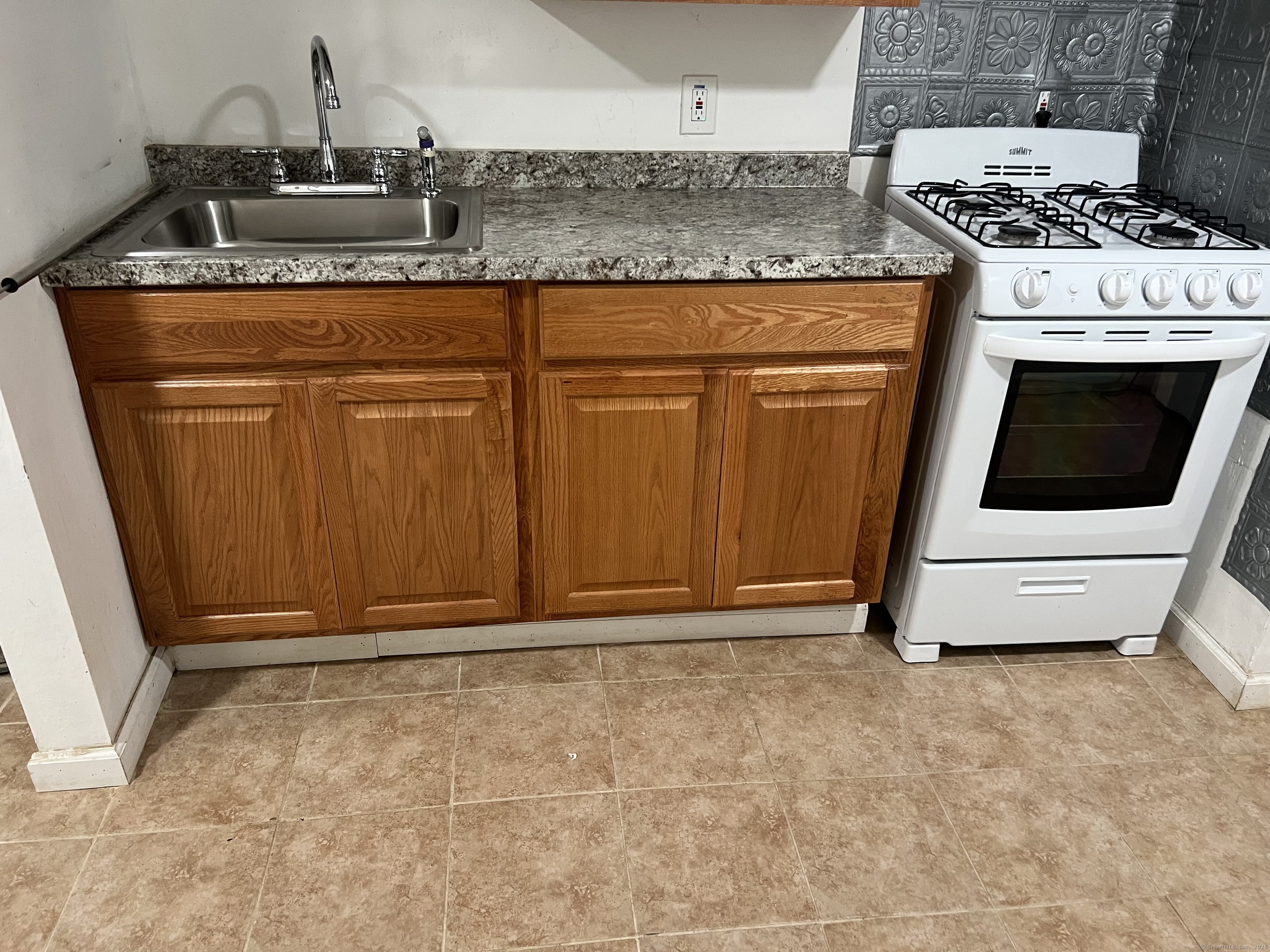 302 Dover Street Bridgeport, CT 06610 - Photo 5 of 15 a kitchen with granite countertop a stove and a sink