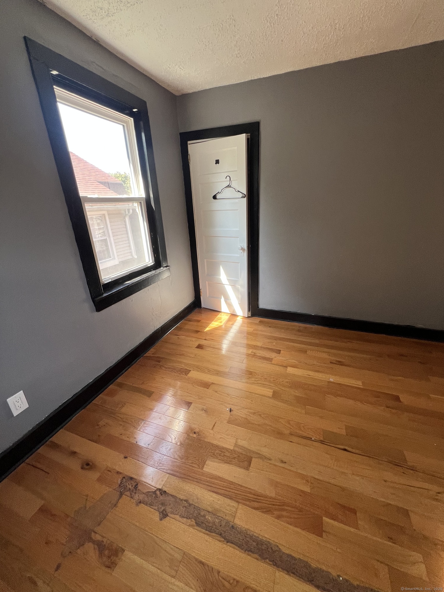302 Dover Street Bridgeport, CT 06610 - Photo 8 of 15 a view of an empty room with window and wooden floor