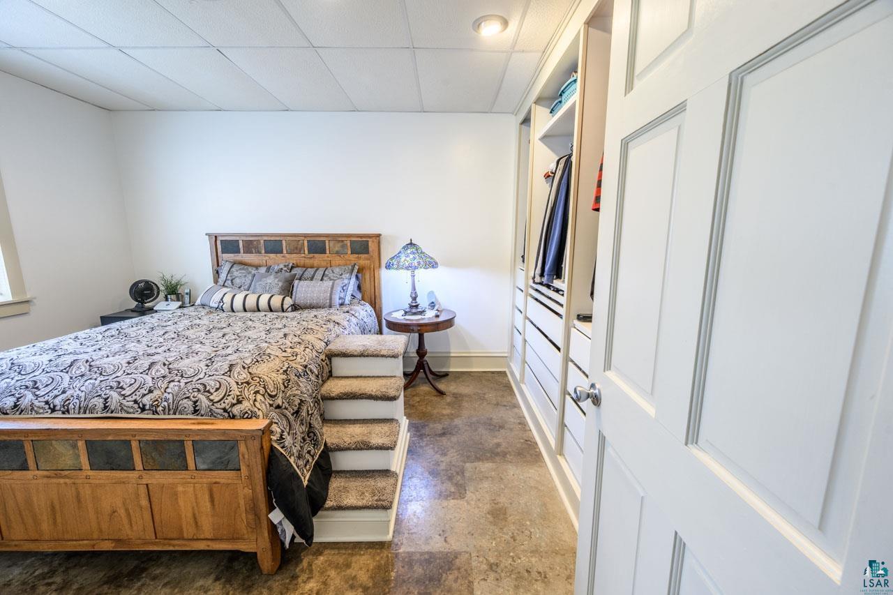 601 Main Street Biwabik, MN 55708 - Photo 18 of 39 Bedroom featuring a custom built-in closet system with multiple drawers and shelving, recessed lighting, drop ceiling, and wood-finish flooring