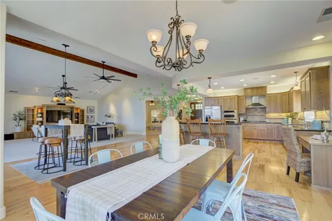 a view of a dining room and livingroom with furniture wooden floor a chandelier