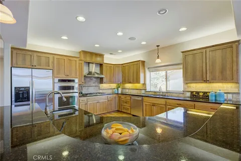 a kitchen with stainless steel appliances granite countertop a sink and cabinets