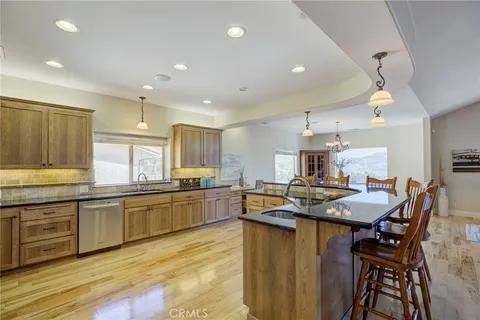 a kitchen with stainless steel appliances granite countertop wooden cabinets a dining table and chairs