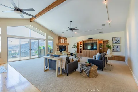 a living room with furniture large window and flat screen tv