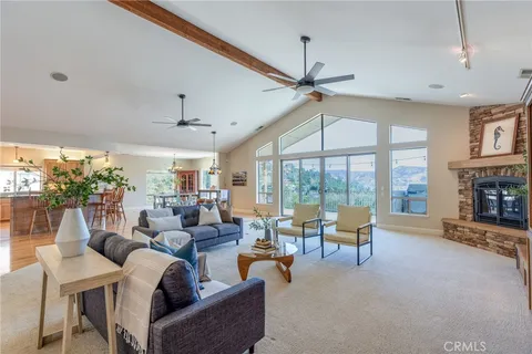 a living room with furniture fireplace and a large window