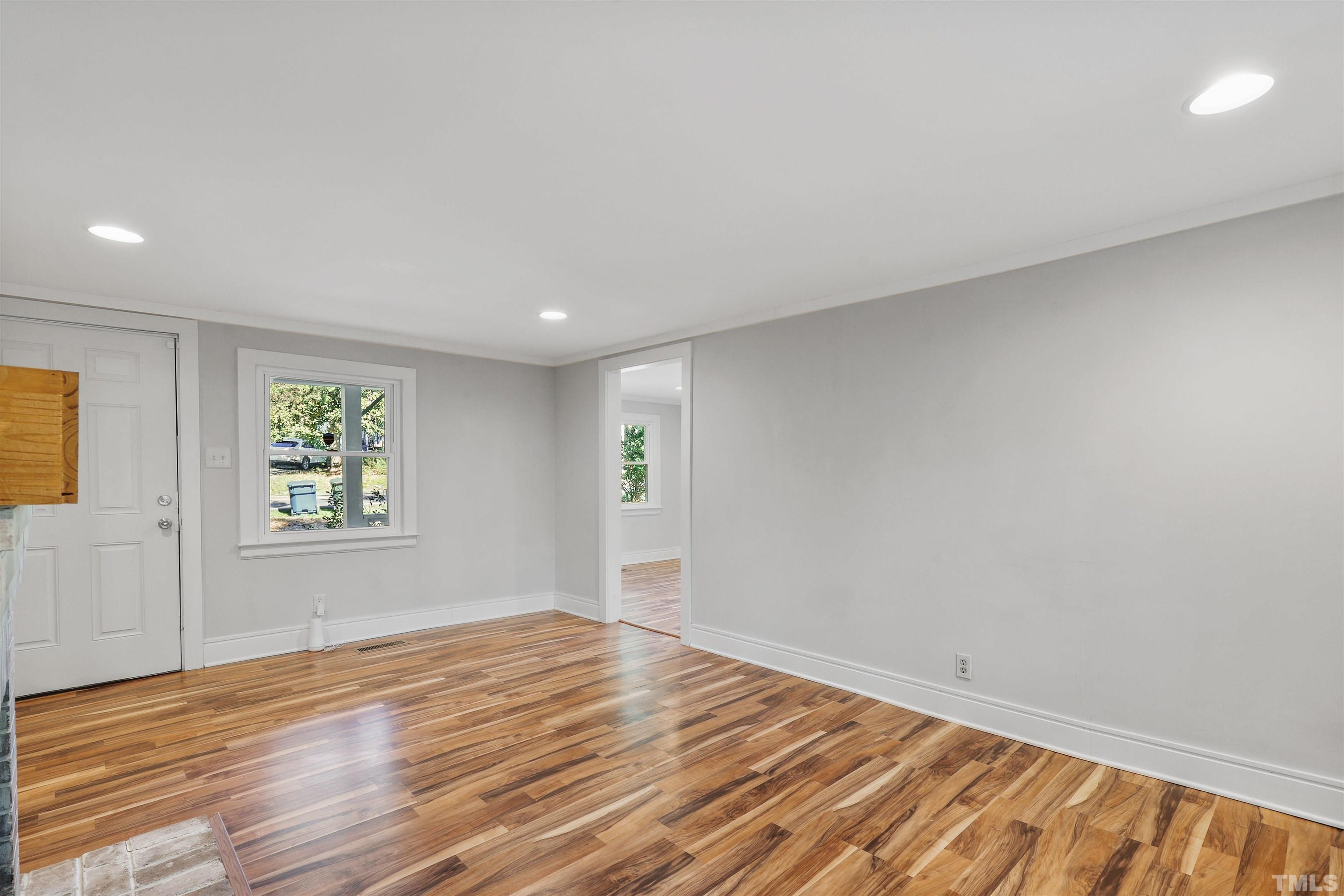 2706 Dearborn Drive Durham, NC 27704 - Photo 2 of 24 an empty room with wooden floor and windows