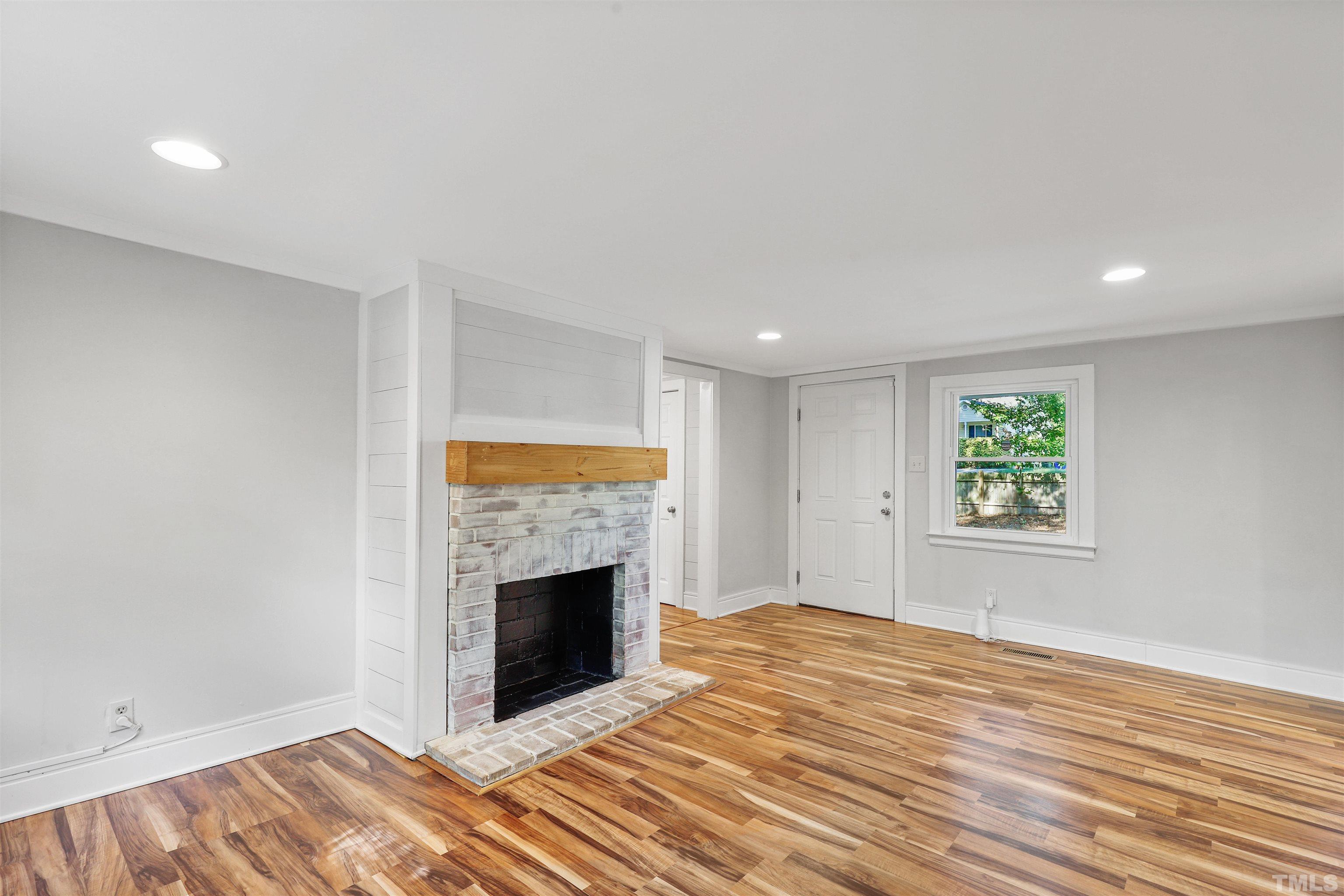 2706 Dearborn Drive Durham, NC 27704 - Photo 3 of 24 an empty room with windows and a fireplace