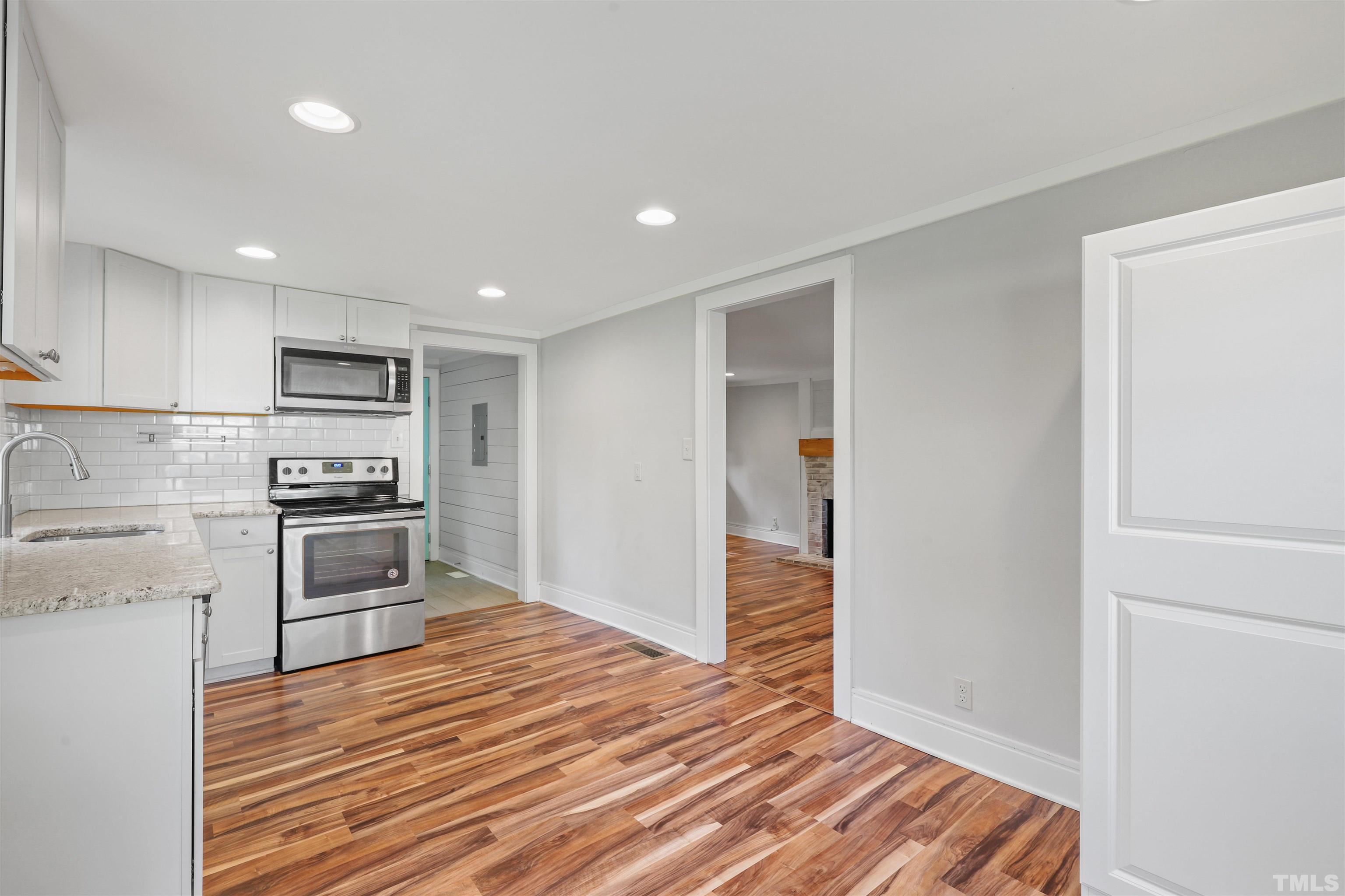2706 Dearborn Drive Durham, NC 27704 - Photo 5 of 24 a kitchen with granite countertop a refrigerator and a stove top oven