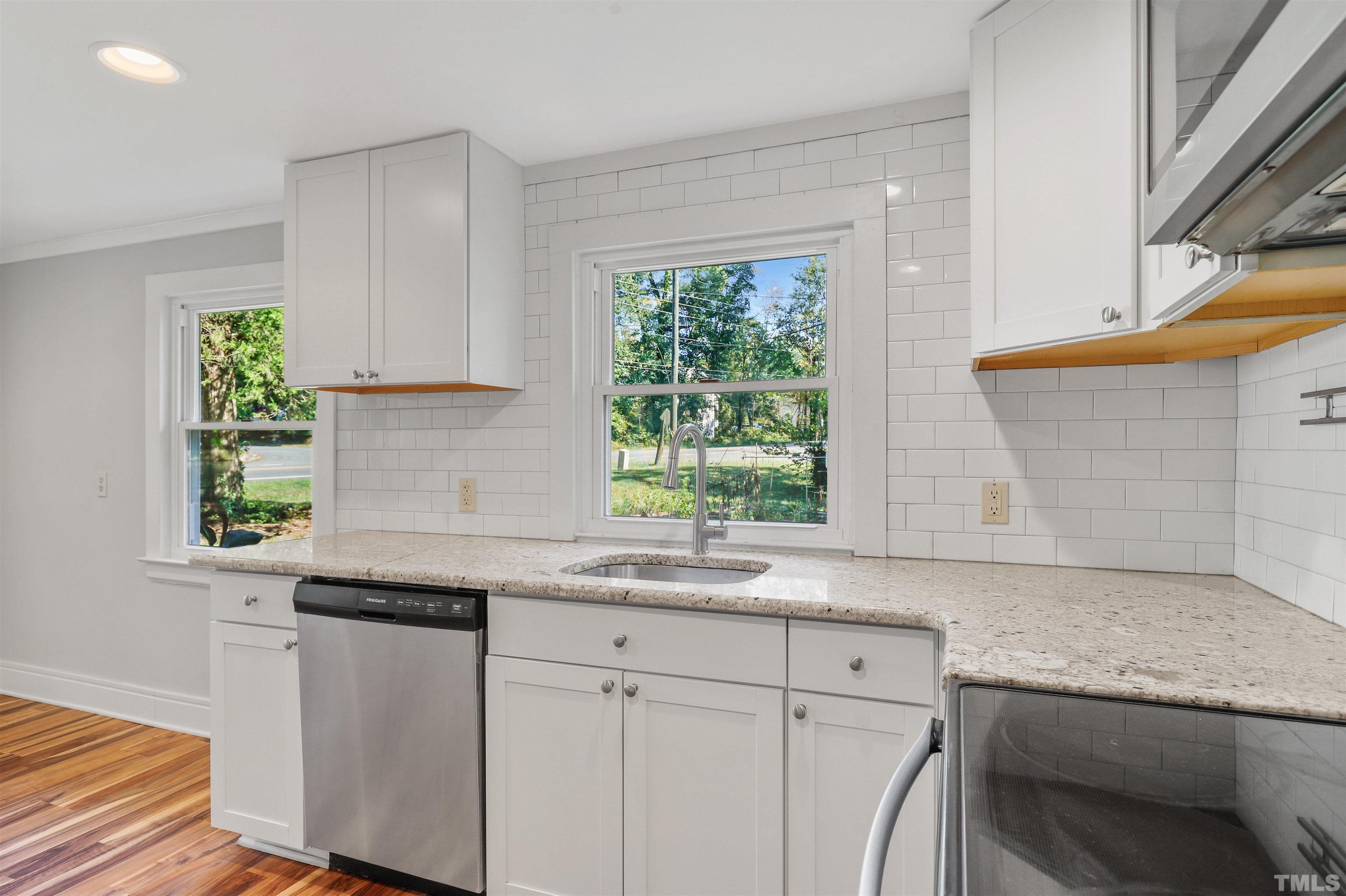 2706 Dearborn Drive Durham, NC 27704 - Photo 7 of 24 a kitchen with granite countertop white cabinets and a window