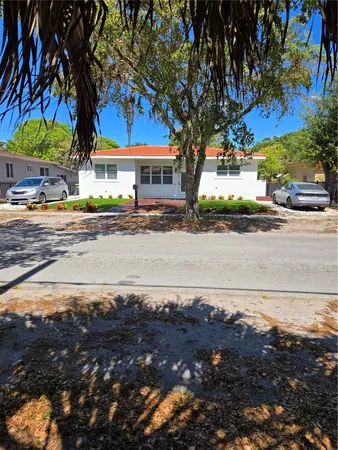a front view of a house with a tree and yard