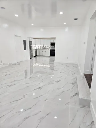 a view of kitchen with microwave and refrigerator
