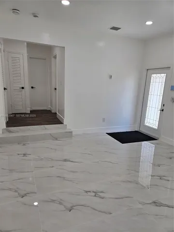 a view of a hallway with wooden floor and closet area