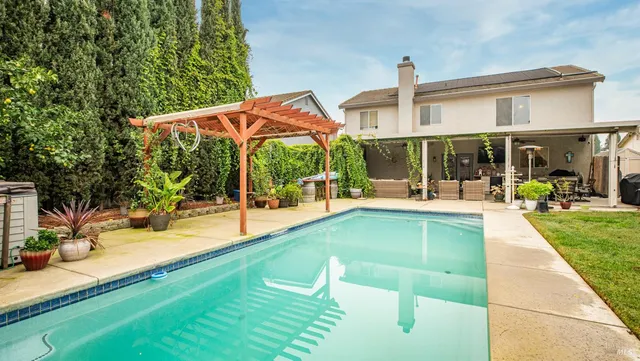 a view of a house with swimming pool and sitting area
