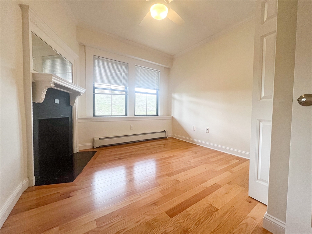 219 Commonwealth Avenue, Unit 12 Newton, MA 02467 - Photo 11 of 12 an empty room with wooden floor and windows