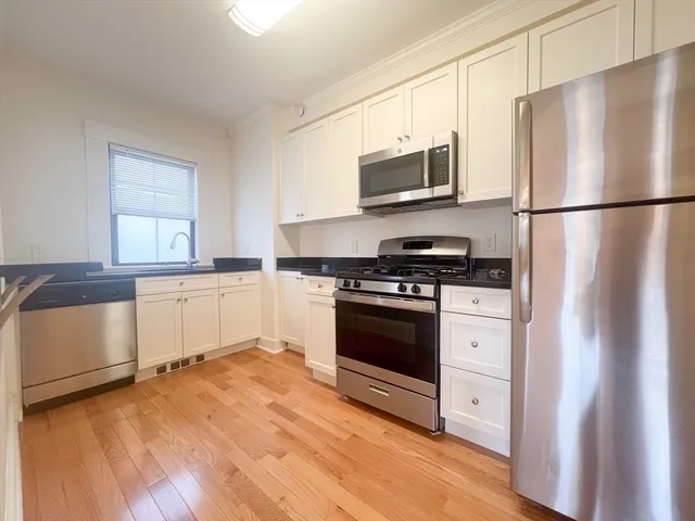 a kitchen with stainless steel appliances a refrigerator stove and microwave