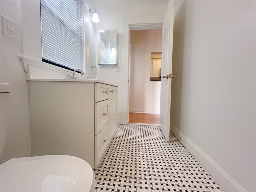 219 Commonwealth Avenue, Unit 12 Newton, MA 02467 - Photo 4 of 12 a bathroom with a sink a toilet a shower and a mirror
