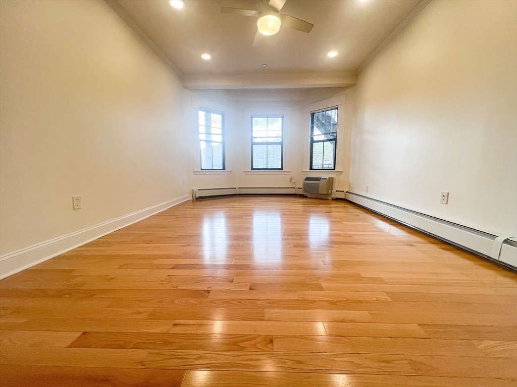 219 Commonwealth Avenue, Unit 12 Newton, MA 02467 - Photo 8 of 12 a view of an empty room with window and wooden floor