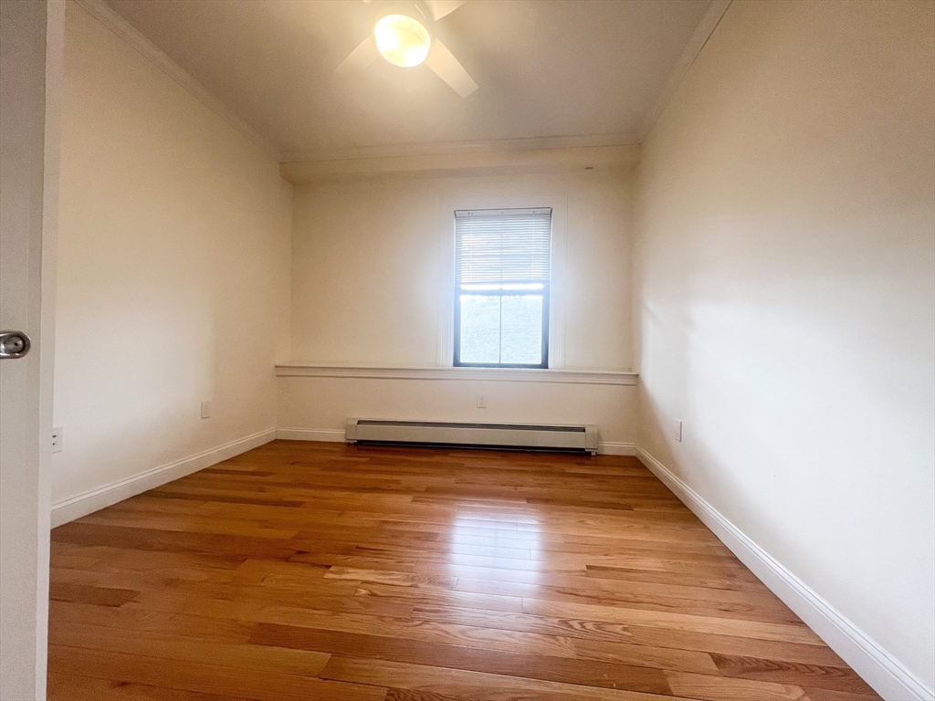 219 Commonwealth Avenue, Unit 12 Newton, MA 02467 - Photo 9 of 12 a view of an empty room with wooden floor and a window