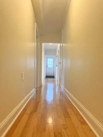 a view of a hallway with wooden floor