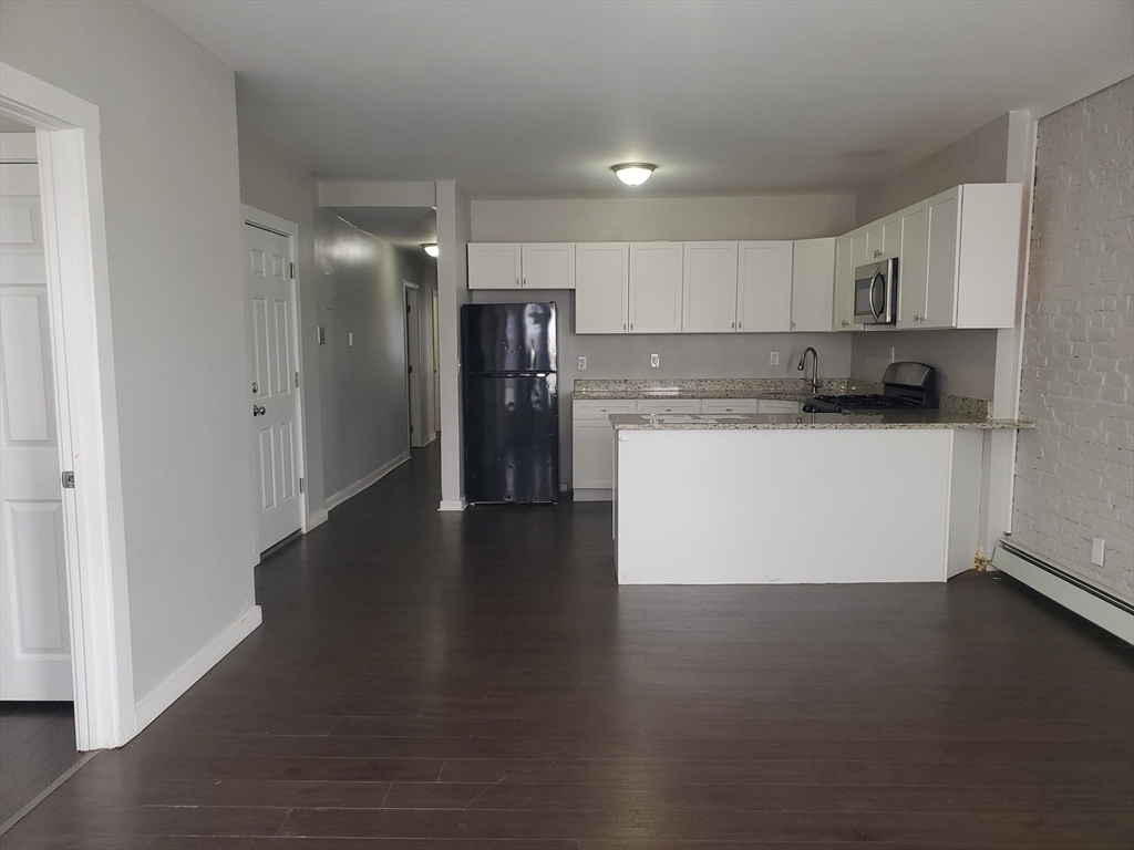 620 Dudley Street, Unit 4 Boston, MA 02125 - Photo 2 of 14 a kitchen with stainless steel appliances a refrigerator and a stove top oven