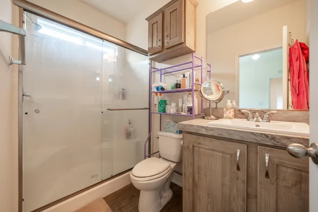 a bathroom with a granite countertop sink toilet and shower
