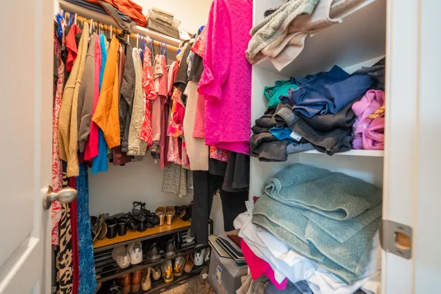 a view of walk in closet with clothes and shoes