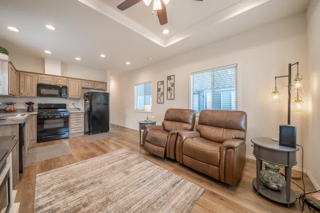 a living room with stainless steel appliances furniture and a kitchen