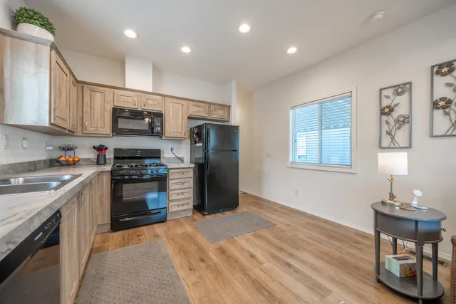 a kitchen with stainless steel appliances granite countertop a refrigerator stove and sink
