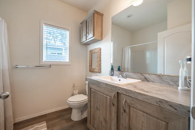 a bathroom with a granite countertop toilet a sink and a mirror