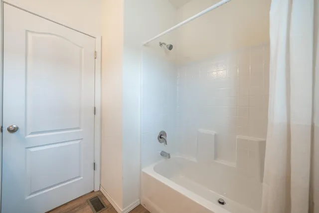 a white bath tub sitting next to a shower