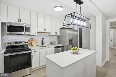 a kitchen with stainless steel appliances a stove microwave and cabinets