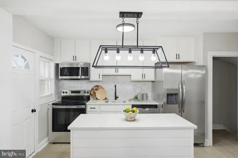 a kitchen with stainless steel appliances a sink a stove and a refrigerator